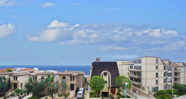 Another view of the ocean and some white water view between the buildings in the middle