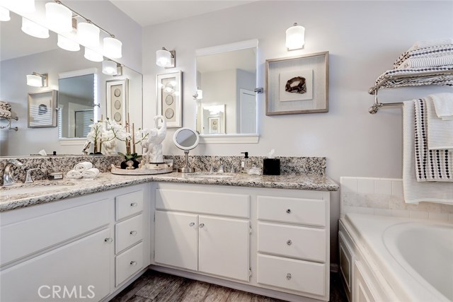 Remodeled master bathroom with dual sink granite countertops and back-lit vanity mirror.