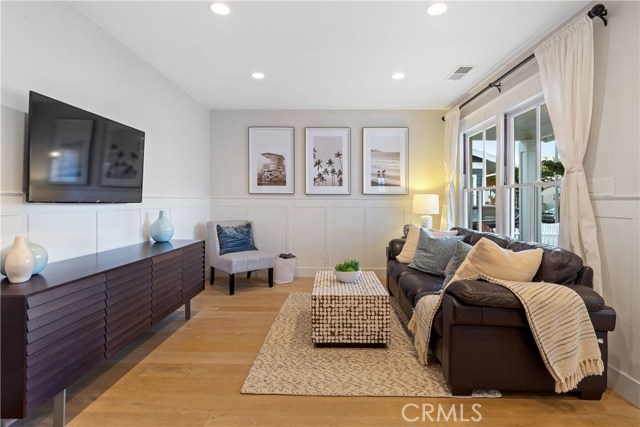 The bright and open great room includes custom wide plank French oak floors and wainscoting that bring warmth and character to the space.