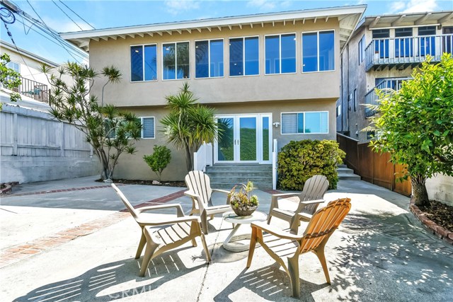 This view of the rear of the house, shows the yard, upper level ocean view windows, the seperate guest entry and the side walkway which leads up to the street.