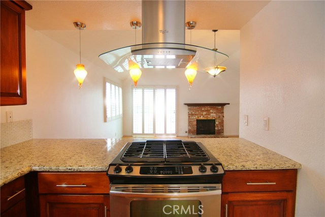 Kitchen view to living room fireplace and balcony sliders.