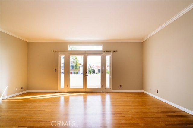 Master bedroom with hardwood floors and double doors to patio