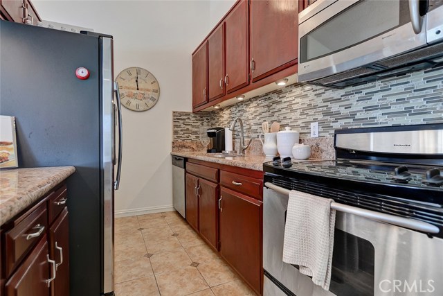 Remodeled kitchen with tile backsplash and stainless appliances.