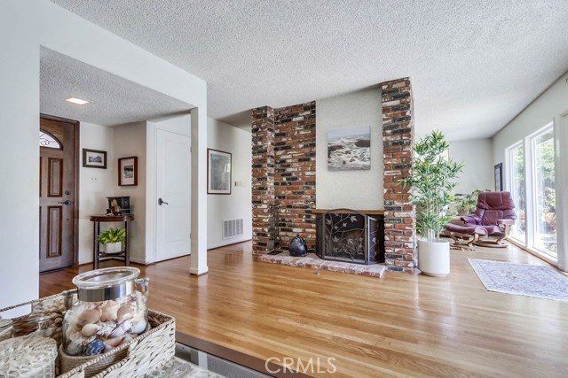 Living room showing den in the background that shares the double sided fireplace