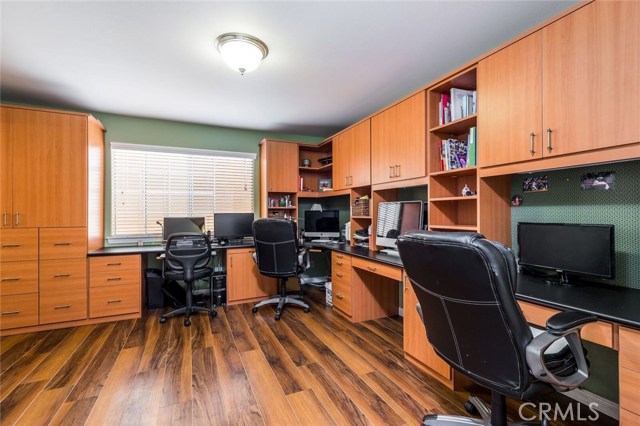 Home office with multiple workstations, custom cabinets and drawers and a full bath.