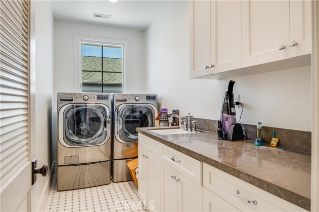 Ample sized laundry room with sink.