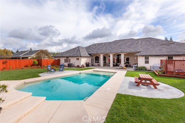 Backyard with beautiful pool, waterfall, patio and plenty of room to play.