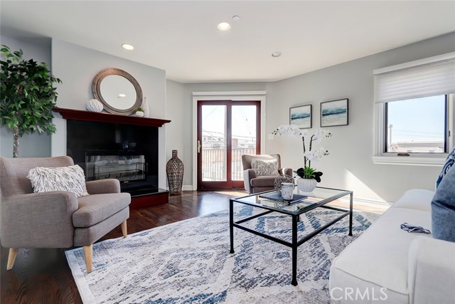 Living room includes recessed lighting, hardwood floors, and a granite gas fireplace.