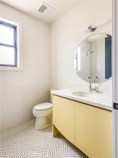 Upstairs full bathroom with floor to ceiling penny tiles, designer cement floor tiles, and cast iron Kohler tub