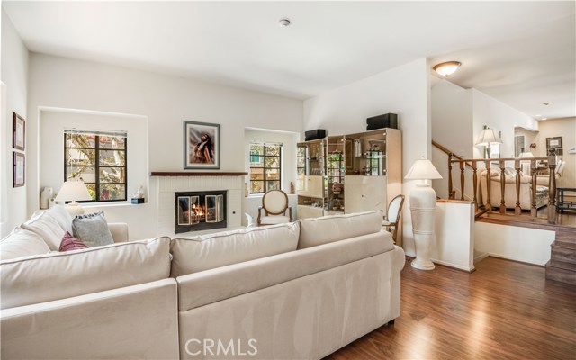 Spacious living room focuses on the beautiful brick fireplace with wood mantlepiece. Light, and bright with ocean breezes, with windows on the west, north and south sides.