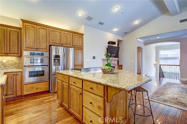 Huge island in a cook's kitchen with granite counters, all stainless appliances, and tons of cabinet space.