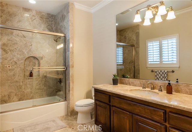The mini master bath features tile flooring, plantation shutters, and a shower / tub combo.