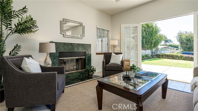 Living Room with fireplace and double french doors open to the private grassy front yard.