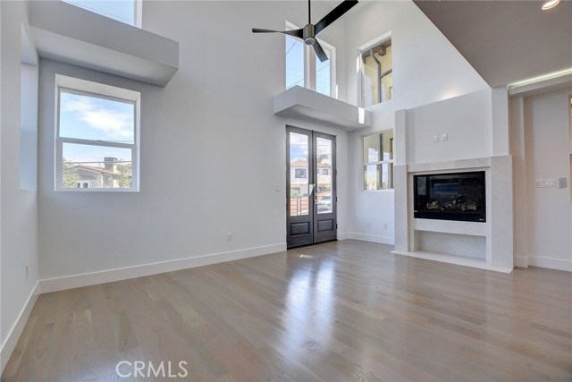 2nd Level . . . Living room with fireplace, ceiling fan, and Juliet balcony