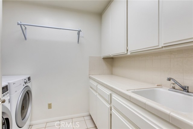 The laundry room is conveniently placed and includes a folding counter and utility sink.