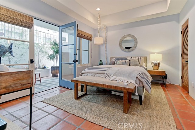 Guest bedroom at lower floor level with adjacent outdoor patio area.