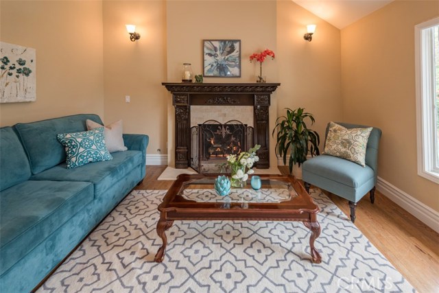 Formal living room with gas fireplace and bay window, cathedral ceilings, sconce lighting, base moudlings.