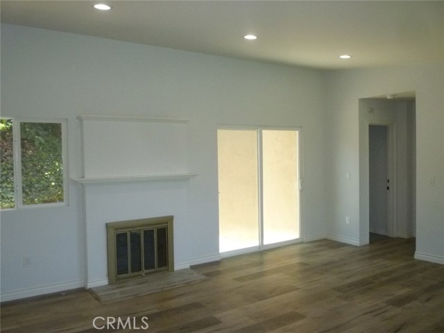 View from the front door looking to the fireplace in the living room.  The glass slider goes out to a side patio.
