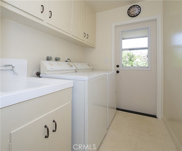 Laundry room with utility sink and door to side yard
