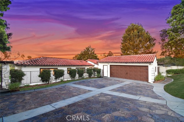 Front behind the perimeter gates shows new red tile roof, new stamped concrete driveway.