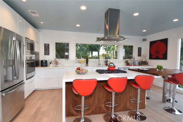 This totally hip new kitchen rocks!  The custom walnut island is gorgeous, and there are cabinets and counter tops galore!
