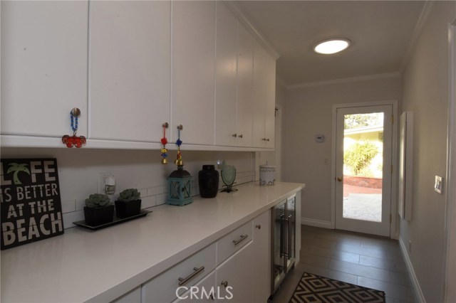 Wonderful Butler's pantry off the kitchen has tons of cabinets and beautiful quartz counters.  Nice built in wine fridge!  There is a ½ bath off of this room, as well as a door to the rear yard and garage!  Nice solatubes keep this room bright and cheerful, like the rest of the house!