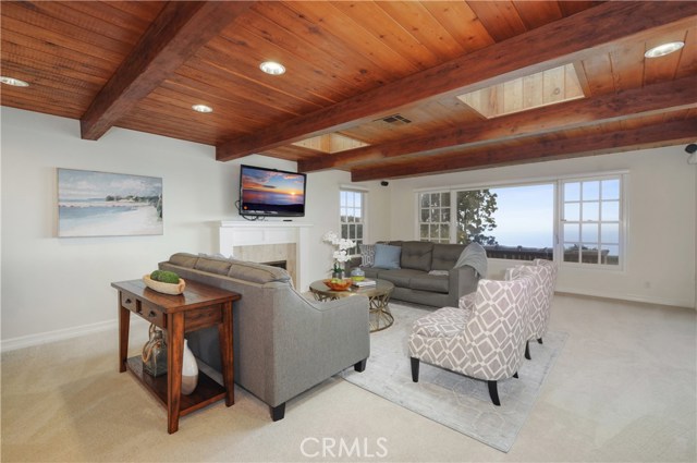 Family room area of the great room with panoramic view and windows on three sides.  It features another lovely fireplace.