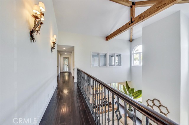Open walkway looking towards back bedrooms + laundry room. Notice the heavy timber beamed/vaulted ceilings, lots of natural light and windows from bedroom #3.