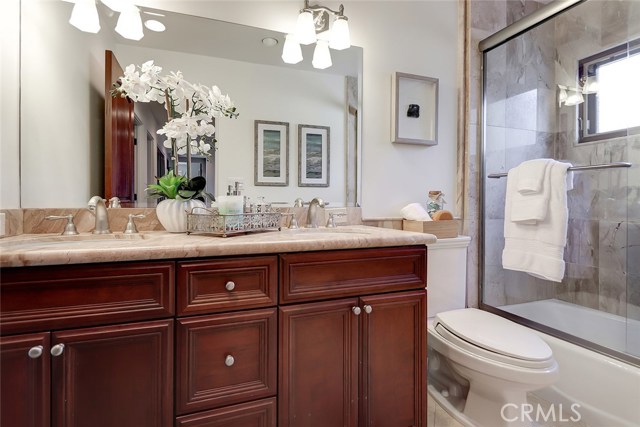 Guest bathroom with combo shower/tub, stone floors and granite countertops.