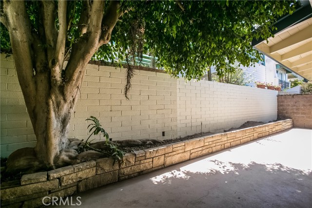 The private rear patio has a long planter and a block wall