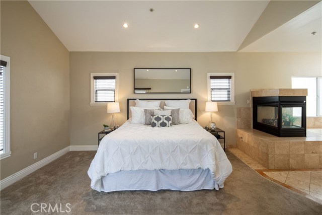 The exquisite master suite located on the upper level is a spacious room with many features including high vaulted ceilings, elegant gas fireplace, access to the deck and rooftop deck, and en-suite bathroom.