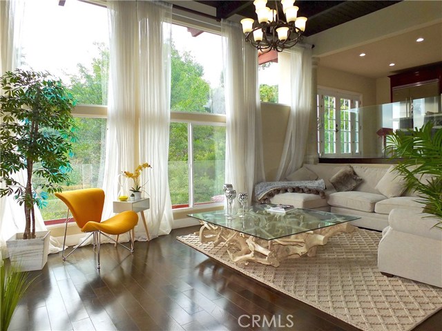 Large, open airy sunken living room in the main house, opens to the expansive deck with treetop views