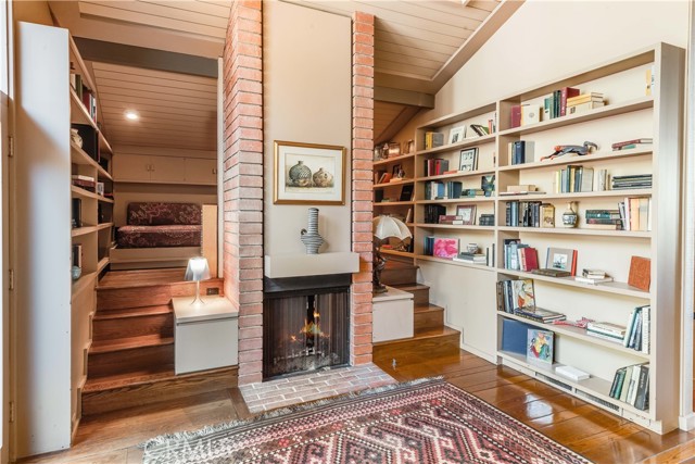 Library with fireplace and upper nook area