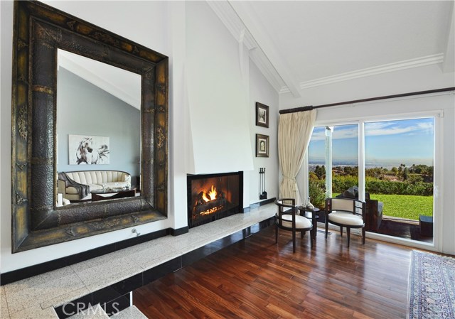 The living room and connected dining room take in the amazing canyon, city, mountain and Long Beach Harbor view and also feature a gas/wood burning fireplace.