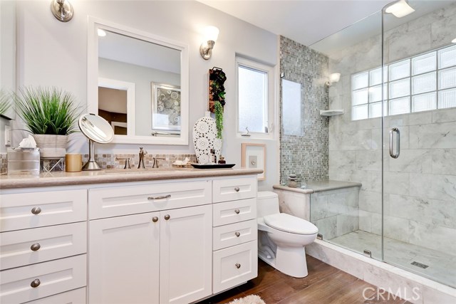Remodeled 3/4 Master Bathroom with Granite Countertop, Porcelain Tiled Flooring, and Glass Enclosed Spa Shower.