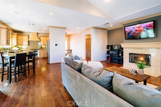 The view of the living room shows its tremendous appeal. A big open space, with the detail and character to give the home a dynamic look and feel. From the crown moldings to the centerpiece fireplace, to the archway and vaulted ceilings, the room has form and function and feel very comfortable while being elegant and chic.