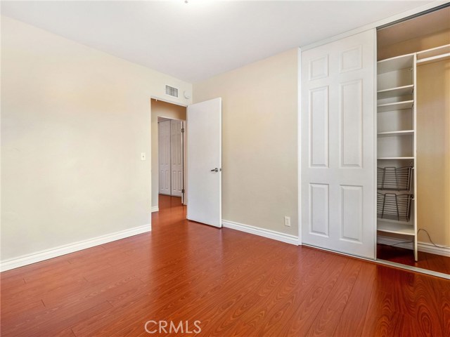 Bedroom #2 with hardwood floors and custom closet built ins.