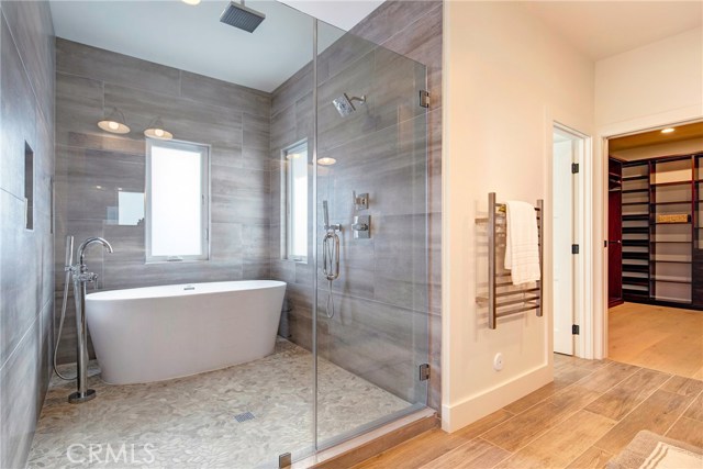 Japanese style walk-in shower and soaking tub with rain shower, porcelain tile, and pebble flooring.  Towel warmers, and massive walk-in closet.