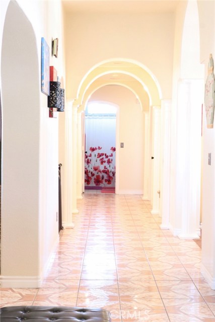 Hall way view from the master bedroom.  The front door would be located at the right of the picture past the first arch.