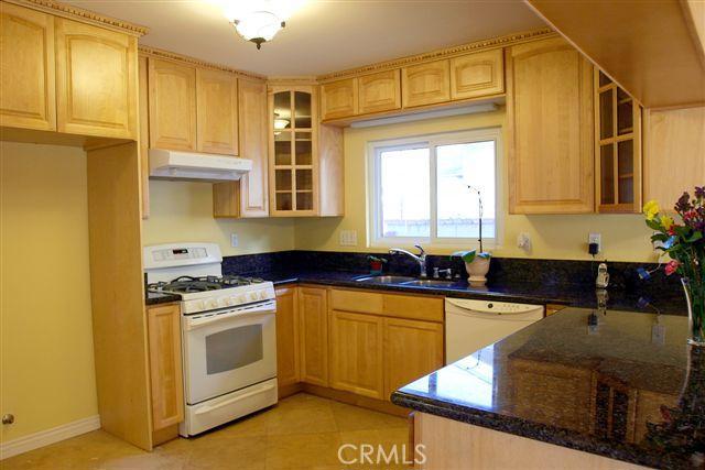 Beautiful remodeled kitchen, with pull-out drawers, slab granite counters & dental-tooth crown molding