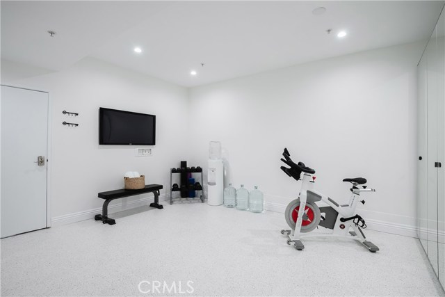 Amazing gym, or bonus space, has been created by enclosing and finishing out the third car garage space and adding epoxy floors, recessed lighting, mirrored floor to ceiling cabinetry, cable/internet hookups, and multiple outlets plus USB charging hub.