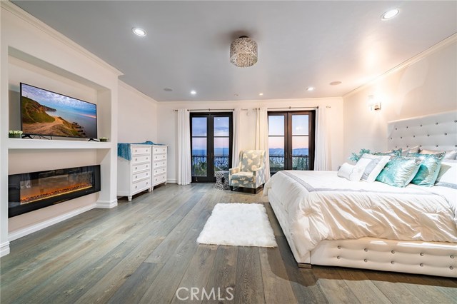 Intensely private master suite is positively gorgeous with outstanding ocean views. This space is large yet still very inviting with sleek fireplace, custom wood flooring and crystal chandelier.