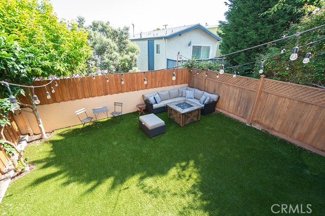 View of spacious backyard from redwood deck area