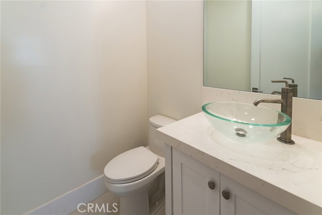 1/2 bath Powder room with quartz counter and glass vessel sink.