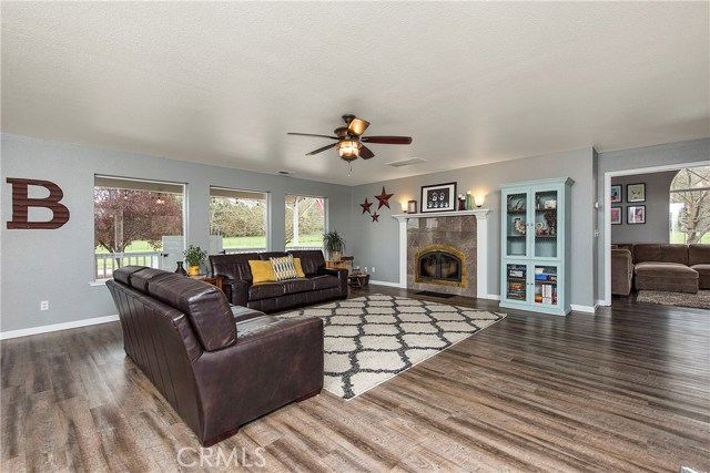 Large living room with wood stove insert with blower, picture windows to covered back porch, and door into family room on the right