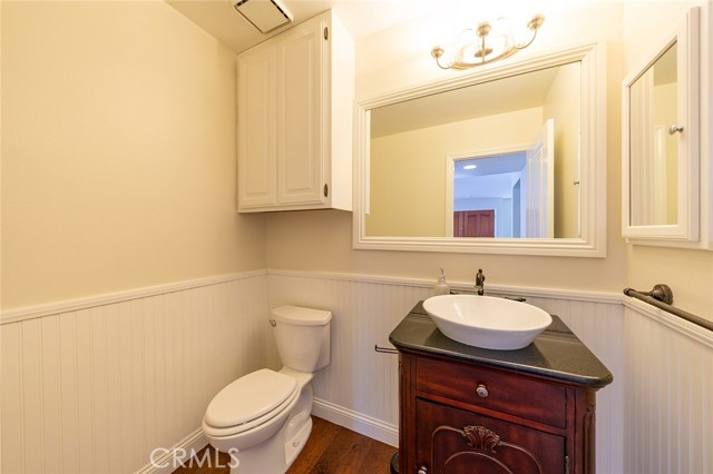 Downstairs powder room with wainscoting and vessel sink.