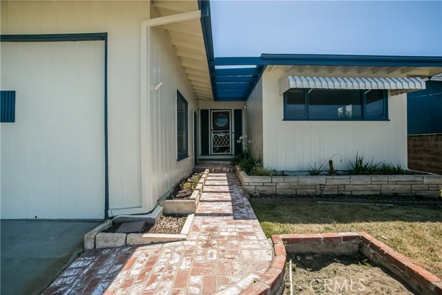 A brick walkway leads to the front entry bordered by planters on either side up to the landing