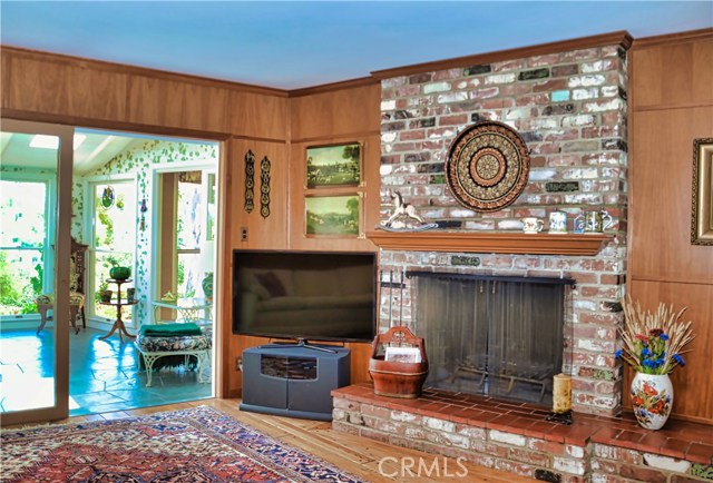 Family room with second fireplace, hardwood floors and access to the spacious sunroom and outside.