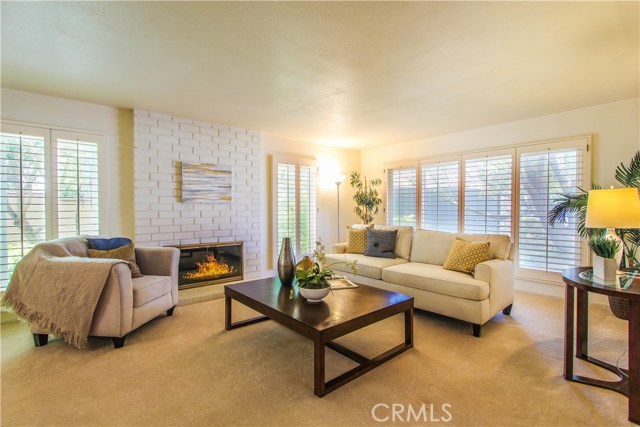 Inviting Living Room with wood burning Fireplace and Plantation Windows.