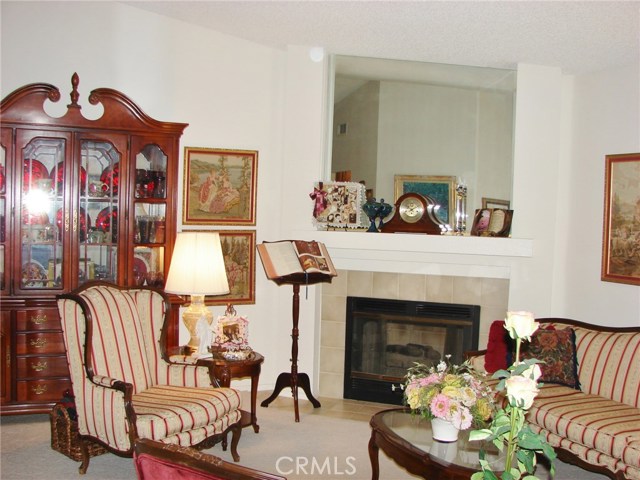 ANOTHER VIEW INSIDE THE LIVING ROOM WITH TILED GAS LOG FIREPLACE.